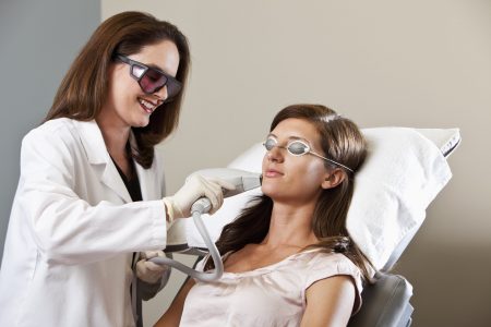 Esthetician performing laser hair removal.